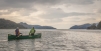 The Enigma Canoes Prospector 16 Tandem Paddling Across Flat Open Water  On A Lake